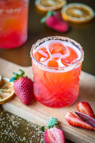 a drink in a glass with strawberries on a cutting board at Park Inn by Radisson Abu Dhabi Yas Island in Abu Dhabi