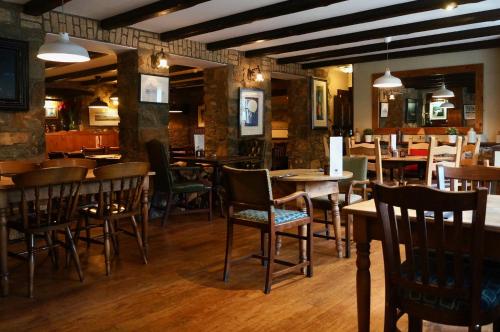 a restaurant with tables and chairs in a room with tables at Castle Inn in Newport Pembrokeshire