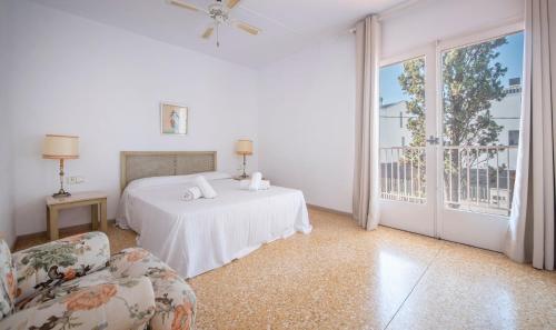 sypialnia z łóżkiem, 2 krzesłami i oknem w obiekcie R31 Casa MONICA w mieście Comarruga