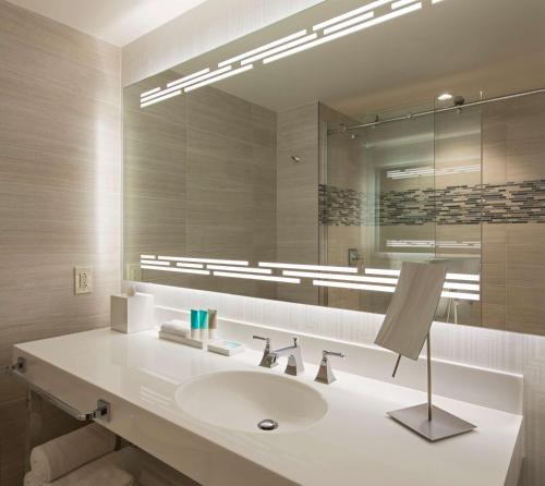 a bathroom with two sinks and a large mirror at Hyatt Regency Dallas in Dallas