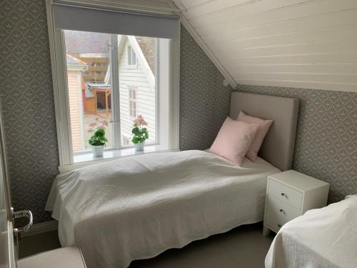 a small bedroom with a bed and a window at Old town boutiqe apartments/ Gamle Lærdalsøyri boutique leiligheter in Lærdalsøyri