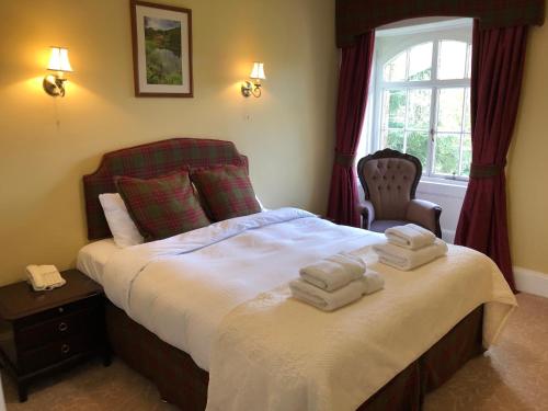 a bedroom with a bed with two towels on it at Coul House Hotel in Contin