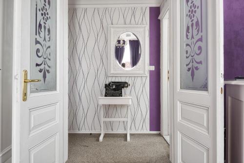 a hallway with a mirror and purple walls at Hotel Galija in Pula