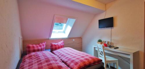 a bedroom with a bed and a desk and a window at Gästehaus Behabühl in Feldberg