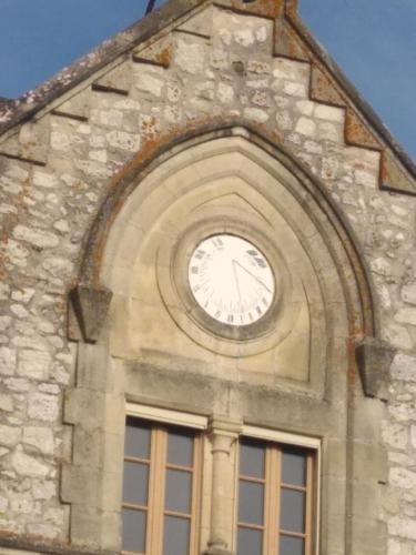 a clock on the side of a building with a window at Gîte La Bastide in Tournon-dʼAgenais