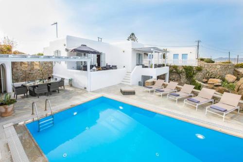 a villa with a swimming pool and a house at Mykonos Psarrou villas for 18 people in Mýkonos City
