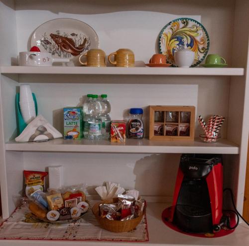 ein Regal mit Lebensmitteln und anderen Gegenständen darauf in der Unterkunft B&B Chiaro di Luna in Corleone