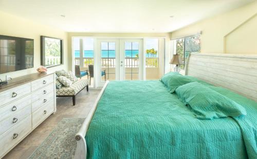 a bedroom with a large bed with a green blanket at Villa Turkuaz in Providenciales