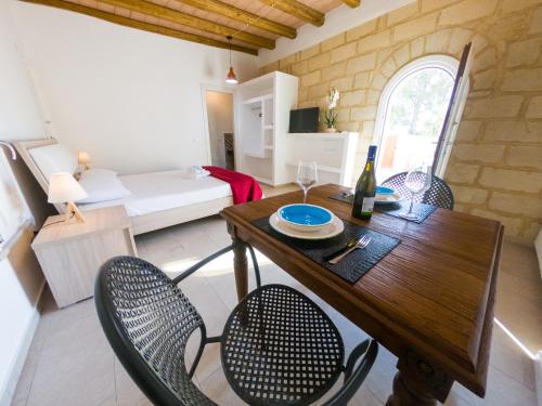a dining room with a table and chairs and a bedroom at Cava Rossa in Favignana