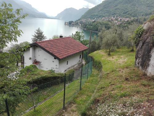 a small house on a hill next to a body of water at casa indipendente "IL SOLE DELLE GRIGNE" in Bellagio