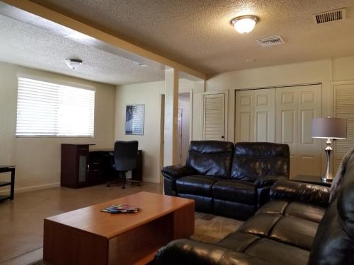 a living room with a leather couch and a table at Quiet Desert Oasis off Swan Rd in Tucson