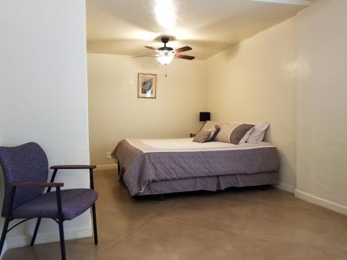 1 dormitorio con 1 cama, ventilador de techo y silla en Quiet Desert Oasis off Swan Rd, en Tucson