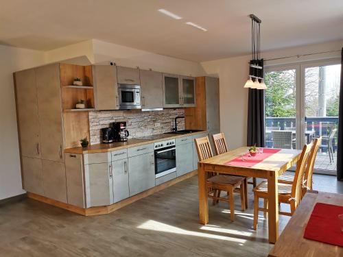 eine Küche mit einem Tisch und einem Esszimmer in der Unterkunft Apartmenthaus Vetter in Kurort Gohrisch