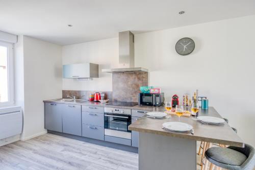 a kitchen with stainless steel appliances and a counter at Le 001-GregIMMO-Appart'Hôtel in Audincourt