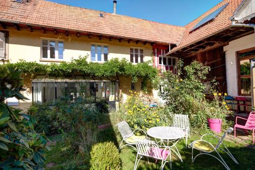 - une table et des chaises dans la cour d'une maison dans l'établissement Un soir d'été - Chambres d'hôtes, à Ernolsheim-Bruche