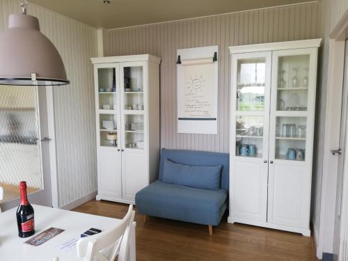 a dining room with a blue chair and a table at Vakantiehuis ''De Bolle'' in Bathmen