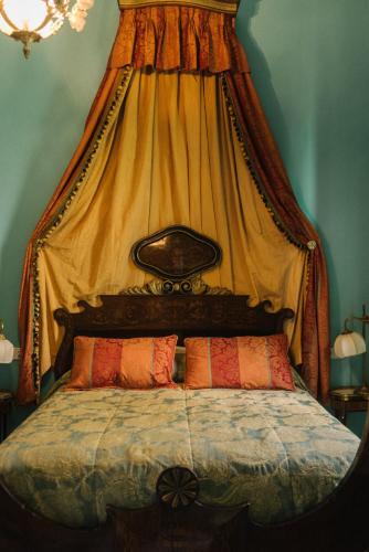 a bed with a canopy with two pillows on it at Palacio del Virrey Laserna in Jerez de la Frontera