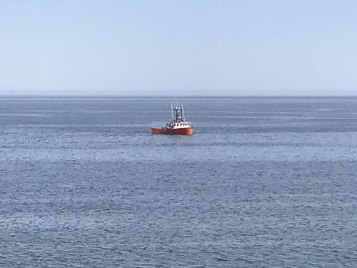 a red boat in the middle of the ocean at Motel La Marina in Matane