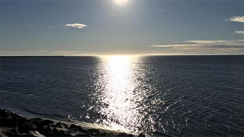 a view of the sun reflecting on the water at Motel La Marina in Matane