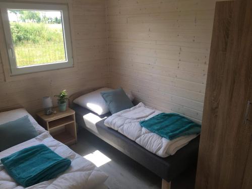 two twin beds in a room with a window at FHU Aquarius in Dziwnówek