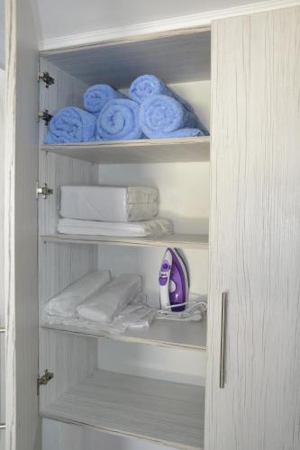 a cupboard with towels and plates and towels at Manolis Studio in Kolimbia