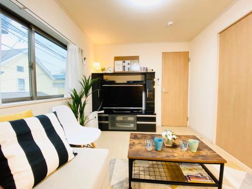 a living room with a white couch and a tv at Naotoko Minpaku #HG1 in Tokyo