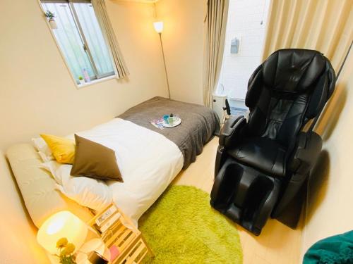 a small bedroom with a bed and a chair at ただいま!と帰りたくなる場所 Naotoko Minpaku #HG1 首都高入口迄5分 広々94平米 一戸建て貸切 高速Wi-Fi 無料駐車場付 in Tokyo