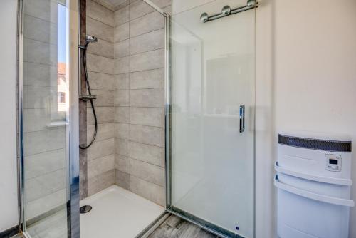a shower with a glass door in a bathroom at Le 001-GregIMMO-Appart'Hôtel in Audincourt
