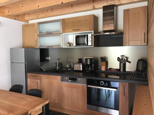 a kitchen with black counter tops and wooden cabinets at Chalet La R'Batte in Sixt
