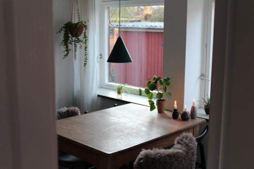 a dining room table with candles and a window at Købmandsgården i Grundfør in Hinnerup