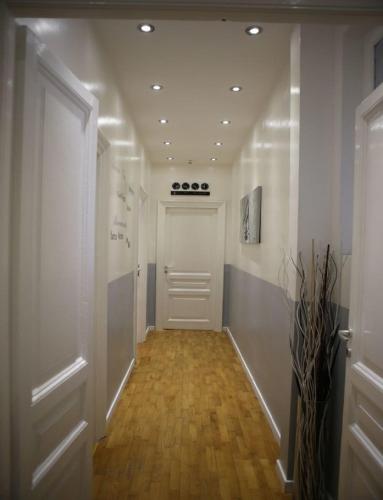 a hallway with a white door and a wooden floor at Vatican Room and Kitchen in Rome