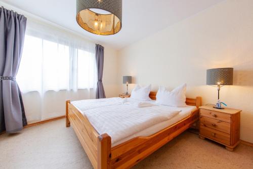 a bedroom with a large bed and a window at Appartementhaus EifelAdventures in Berlingen