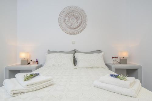 a bedroom with a white bed with towels on it at Orkos Naxian Wave 2 in Mikri Vigla