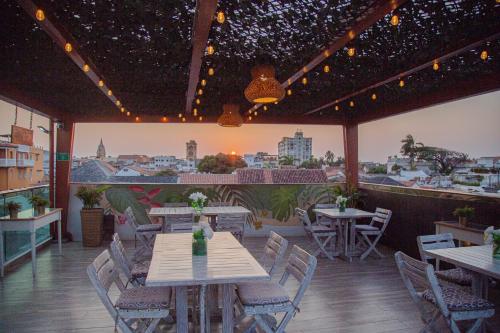 ein Restaurant mit Tischen und Stühlen und Stadtblick in der Unterkunft Hotel Cartagena Royal Inn in Cartagena de Indias