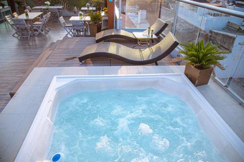 uma banheira de hidromassagem num pátio com cadeiras e mesas em Hotel Cartagena Royal Inn em Cartagena das Índias