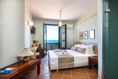Schlafzimmer mit einem Bett und Meerblick in der Unterkunft Ink Hotels House of Europe in Rethymno