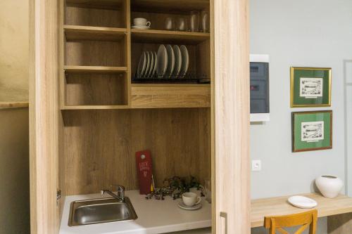 una cocina con fregadero en un armario de madera en Ink Hotels House of Europe, en Rethymno