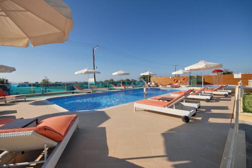 a pool with a row of lounge chairs and umbrellas at Princess Of Naxos in Naxos Chora