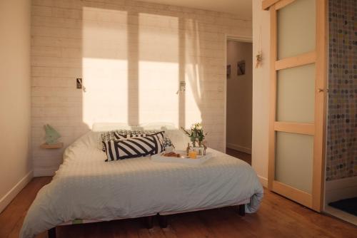 a bedroom with a bed with a window at Les Chambres d'Hôtes de la Mer in Merlimont