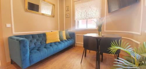 a blue couch in a living room with a table at Afonso Galo Guest Apartments II in Almada