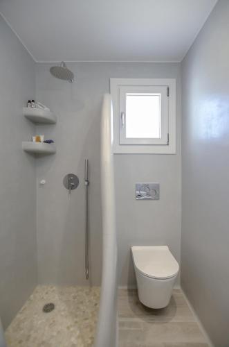 a white bathroom with a toilet and a window at Orkos Naxian Wave 2 in Mikri Vigla
