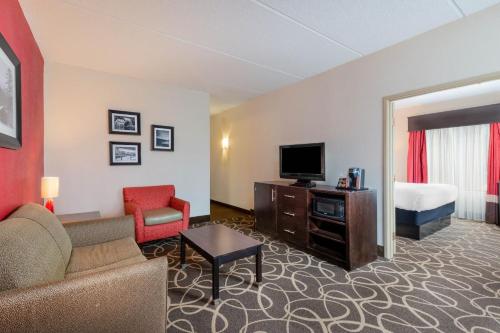 a hotel room with a couch and a tv and a bed at La Quinta Inn & Suites - New River Gorge National Park in Summersville