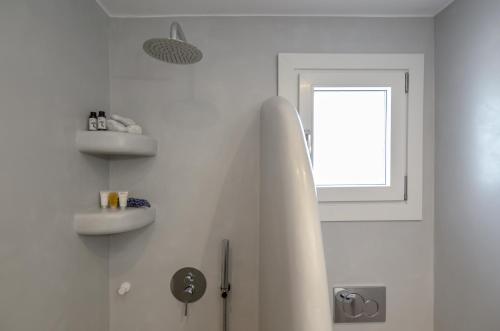 a white bathroom with a tub and a window at Orkos Naxian Wave 2 in Mikri Vigla