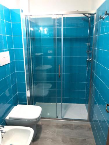 a blue bathroom with a toilet and a glass shower at Mareblù in Scilla