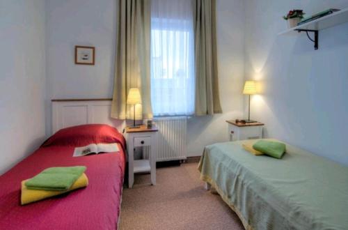 um quarto com 2 camas com lençóis verdes e vermelhos em Villa Baltic -Apartament nr 9 em Chałupy