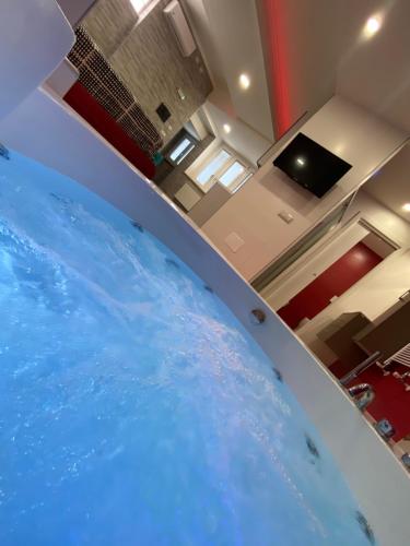 una grande piscina di acqua blu in una stanza di Sweet Home & Wellness Luxury Apartment a Nettuno