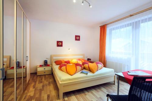 um quarto com uma cama com almofadas laranja e amarela em Appartement Gisela em Sölden