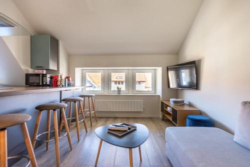 un salon avec un canapé et une cuisine dans l'établissement Le 201-GregIMMO-Appart'Hôtel, à Audincourt