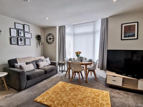 uma sala de estar com um sofá e uma mesa em Sandalwood Apartment - Saltburn by the Sea em Saltburn-by-the-Sea