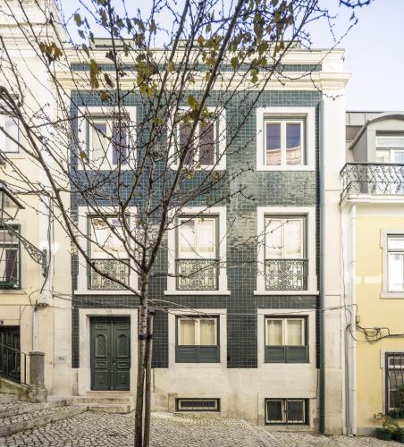 an apartment building with a tree in front of it at Casas na Portuguesa - Bica Chiado in Lisbon